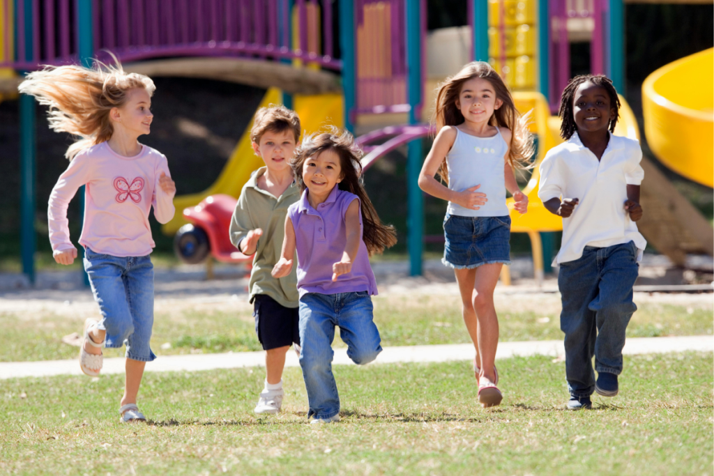 Group of happy children running together at a playground, symbolizing inclusion, confidence, and the importance of play for neurodivergent kids to thrive.