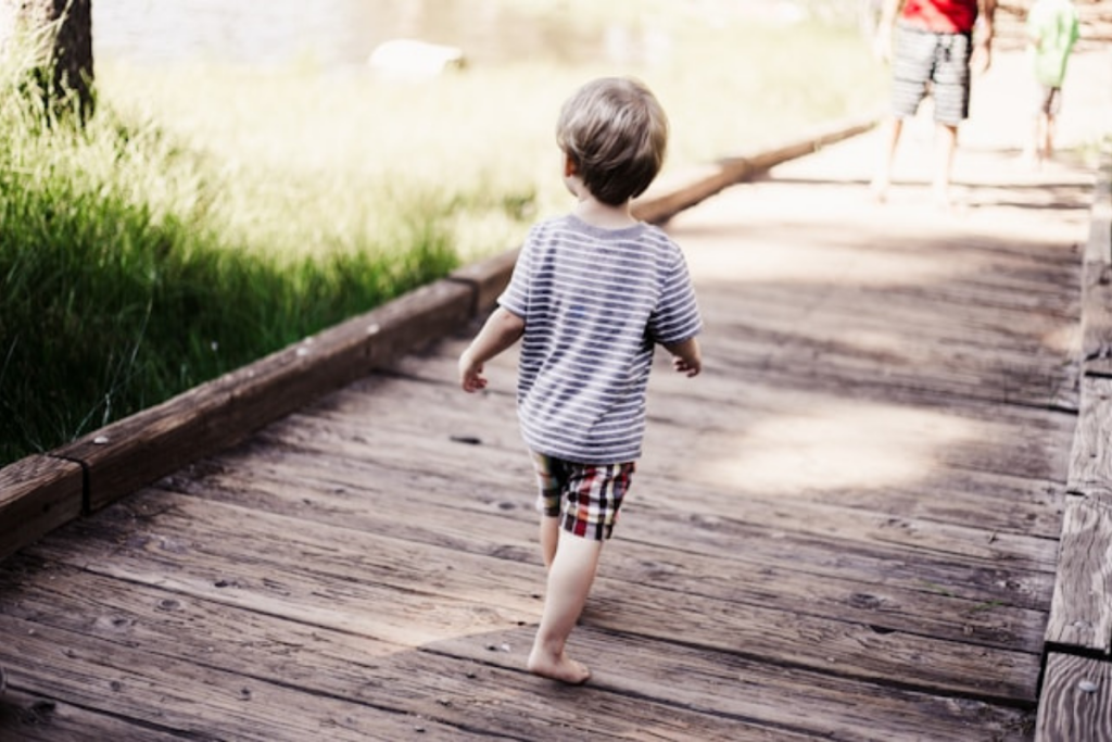 A young boy walking on a wooden path outdoors, symbolizing the journey parents take to be an advocate for your child in education and life.