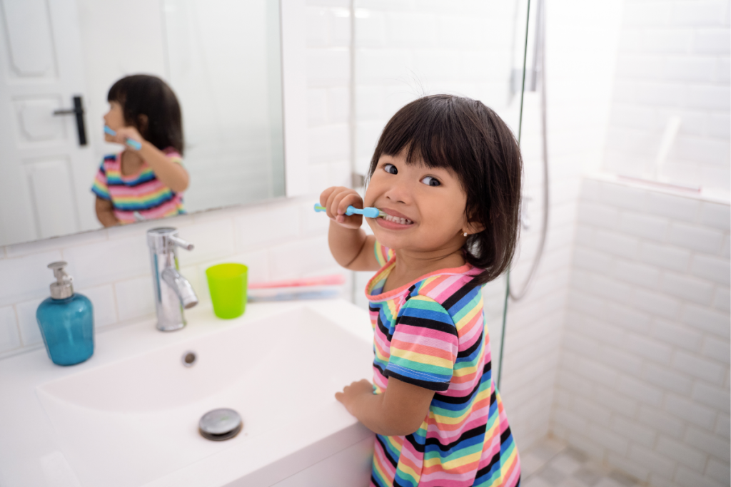 Young girl brushing her teeth independently, symbolizing empowering independence in ND children through daily routines.