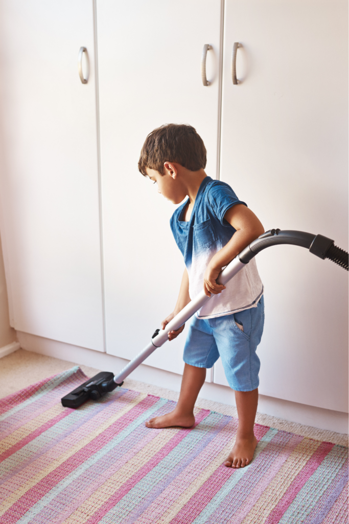 Boy vacuuming a rug as part of everyday routines that build independence and support advocacy for ND children.