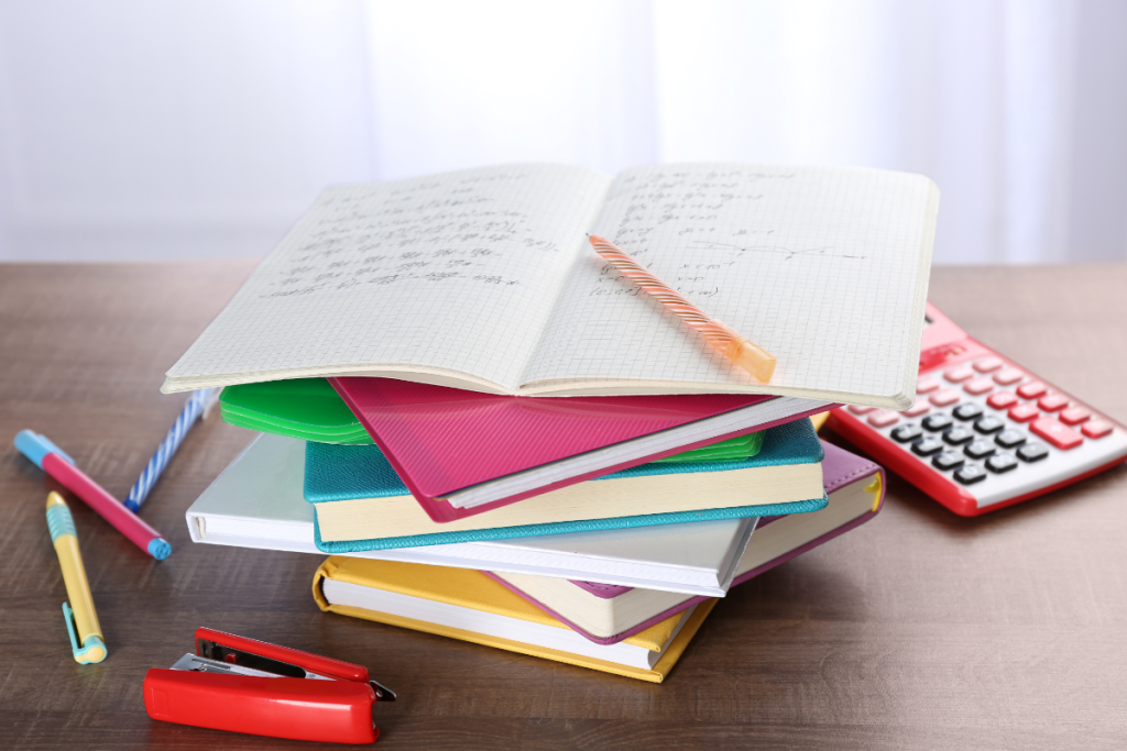 A stack of notebooks, folders, and school supplies on a desk, symbolizing the preparation mamas need because advocacy isn’t optional in the IEP process.