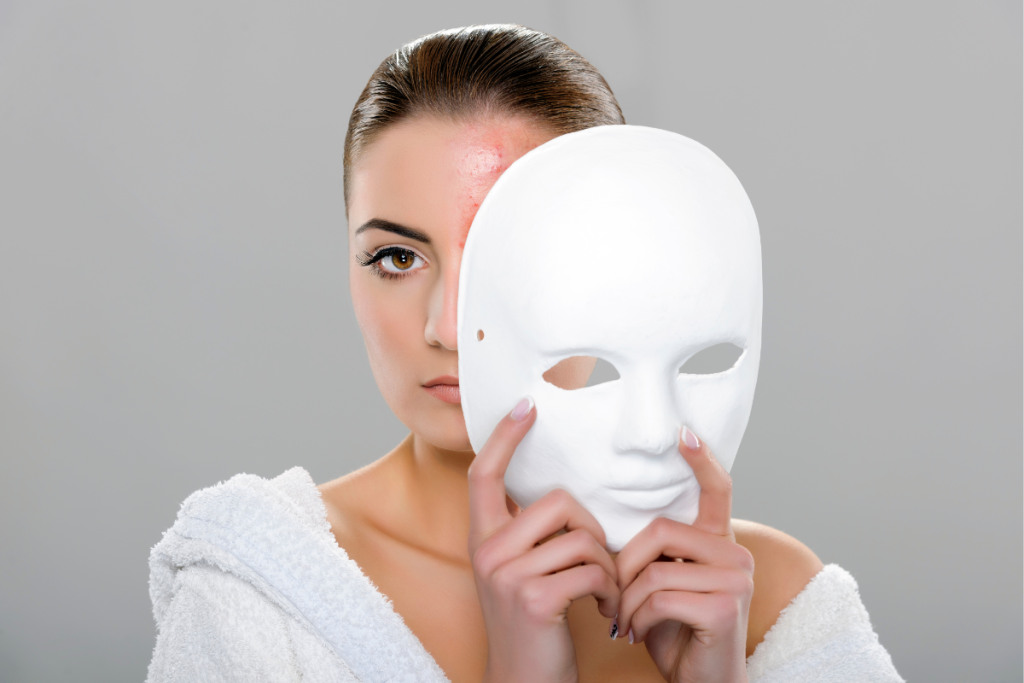 A woman removes a blank white mask to reveal only half of her real face, visually representing ND masking and the hidden emotional effort neurodivergent children use to appear “fine” in social settings.