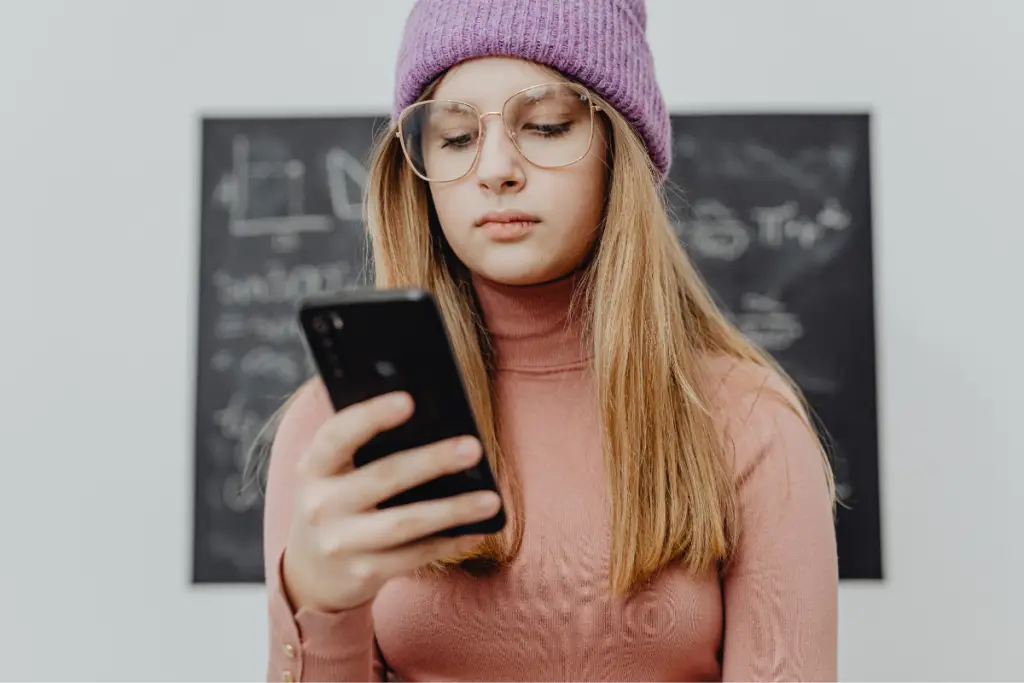 Teen with autism and ADHD traits concentrating on a smartphone, illustrating AuDHD parenting and the cognitive load of divided attention.