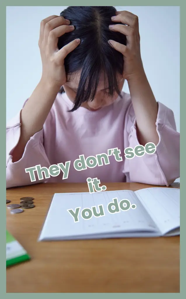 A school-aged child holding their head in frustration while sitting at a desk with an open workbook, illustrating the stress families face when schools don’t see the problem despite a child struggling.
